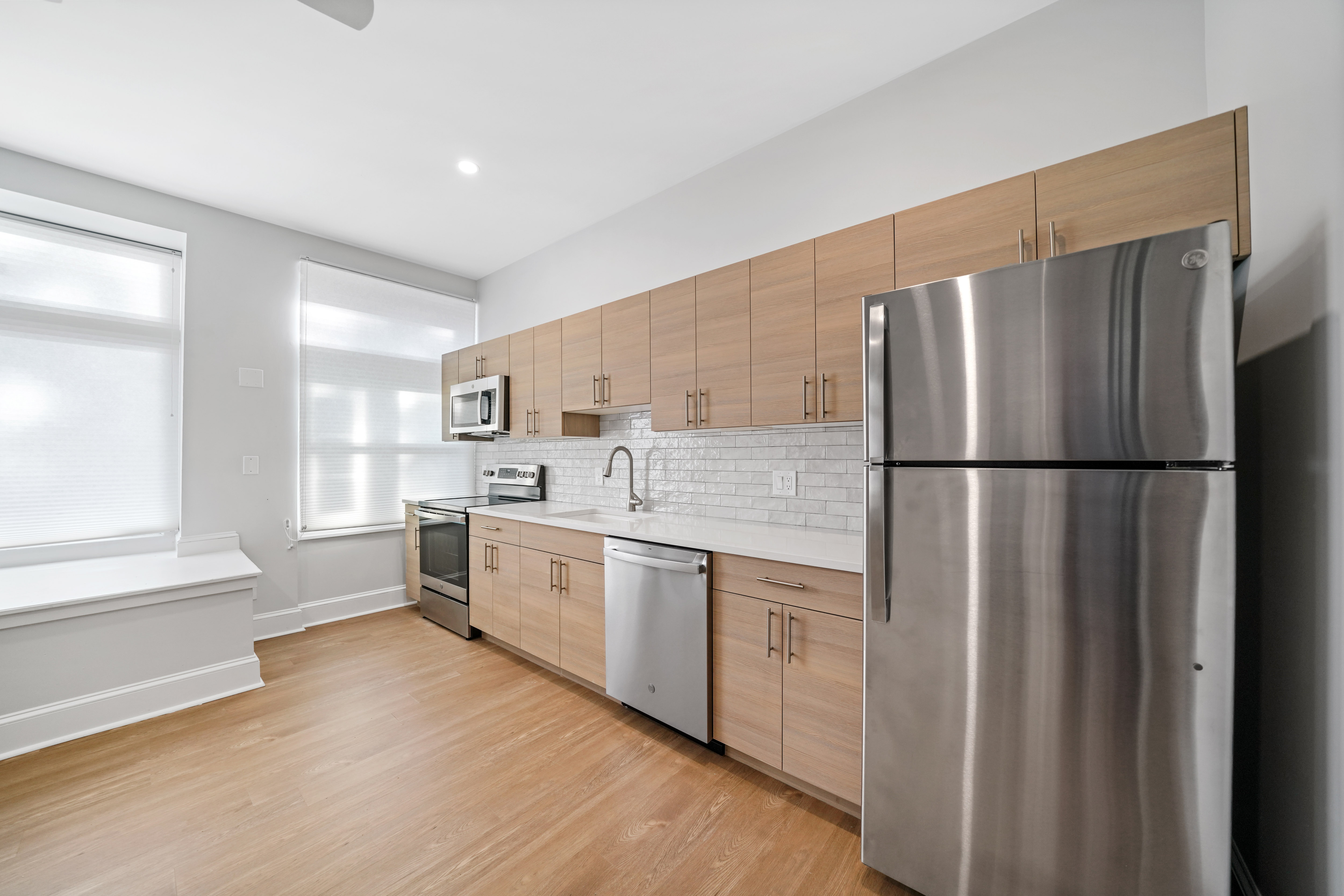 a kitchen with wooden cabinets and a stainless steel refrigerator